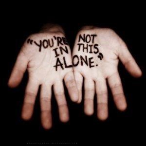 Open hands with "You're not in this alone" written on them.