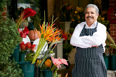 Hispanic florist in front of shop