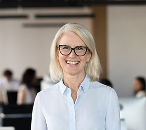 Cheerful senior businesswoman in glasses looking at camera